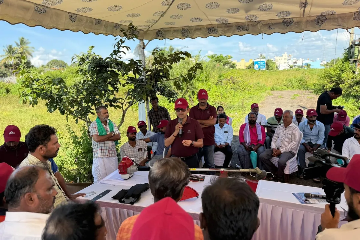 Speaker in a Rancher cap briefing seated farmers with the RXB45 laid out in parts on a table