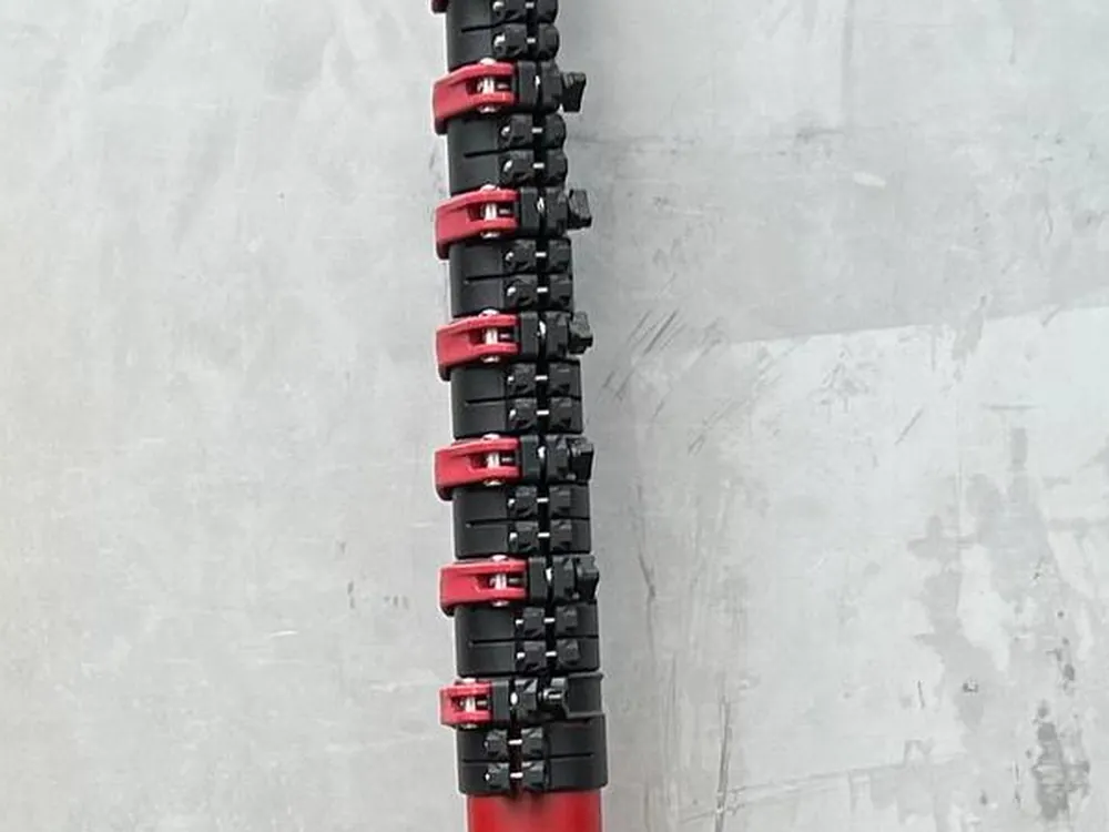 Macro view of the Rancher Doti double-lock clamps, red levers paired down the black collar section