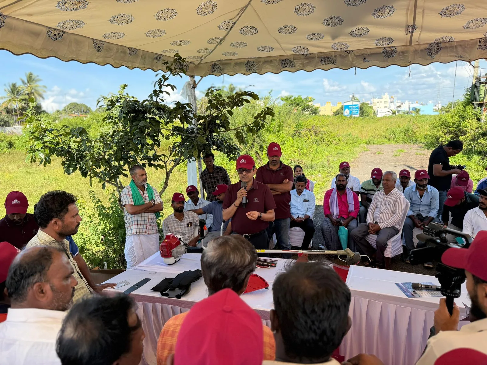 Speaker briefing seated farmers with the RXB45 laid out in parts on a table