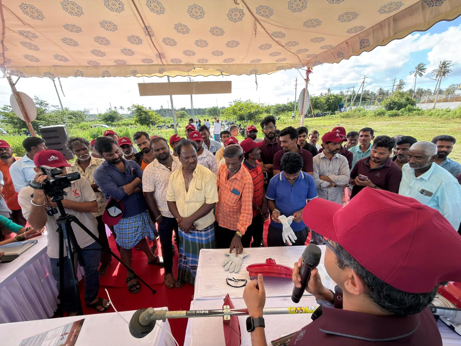 Presenter showing gloves, goggles and the RXB45 guard to a crowd of farmers at a table